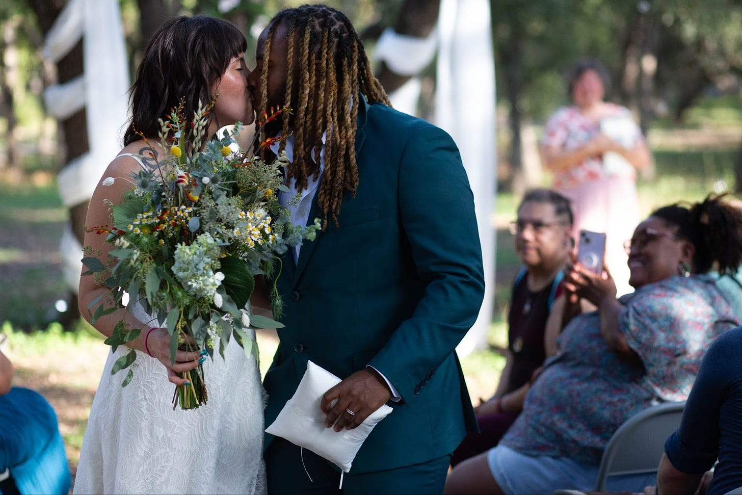 KB and their bride kissing.