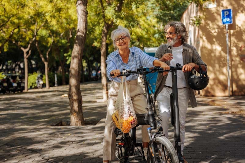 Active elder couple biking home with groceries