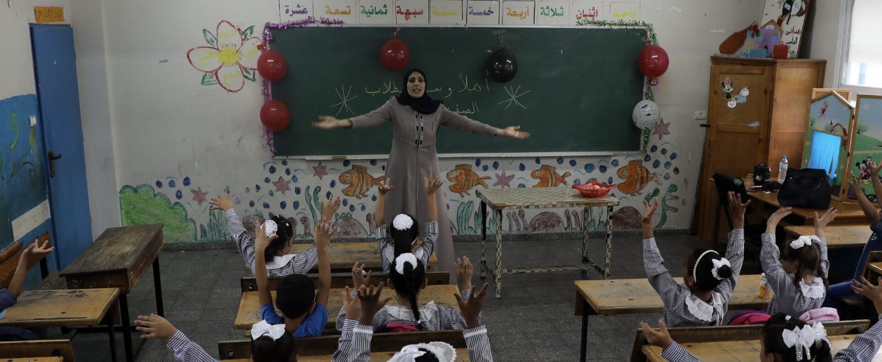 Opettaja on vuorovaikutuksessa oppilaiden kanssa UNRWA:n ylläpitämän koulun luokkahuoneessa uuden kouluvuoden alkaessa Jabalian pakolaisleirillä Gazan kaupungissa 8. elokuuta 2020. (Majdi Fathi/NurPhoto via Getty Images).