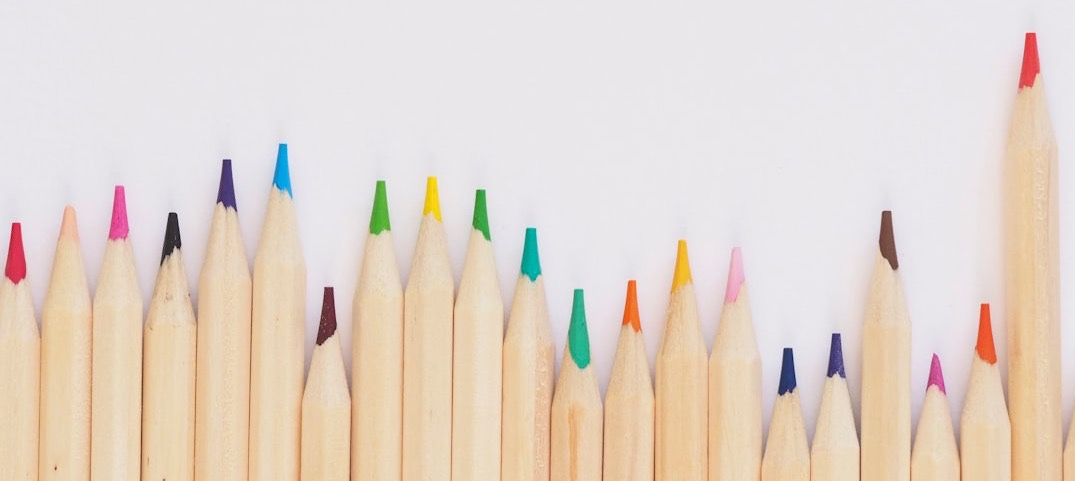 colored pencil lined up on top of white surface