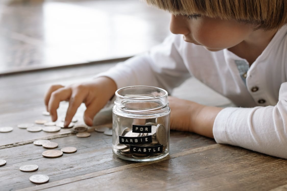 Free Little Child Playing with Coins on Floor Stock Photo