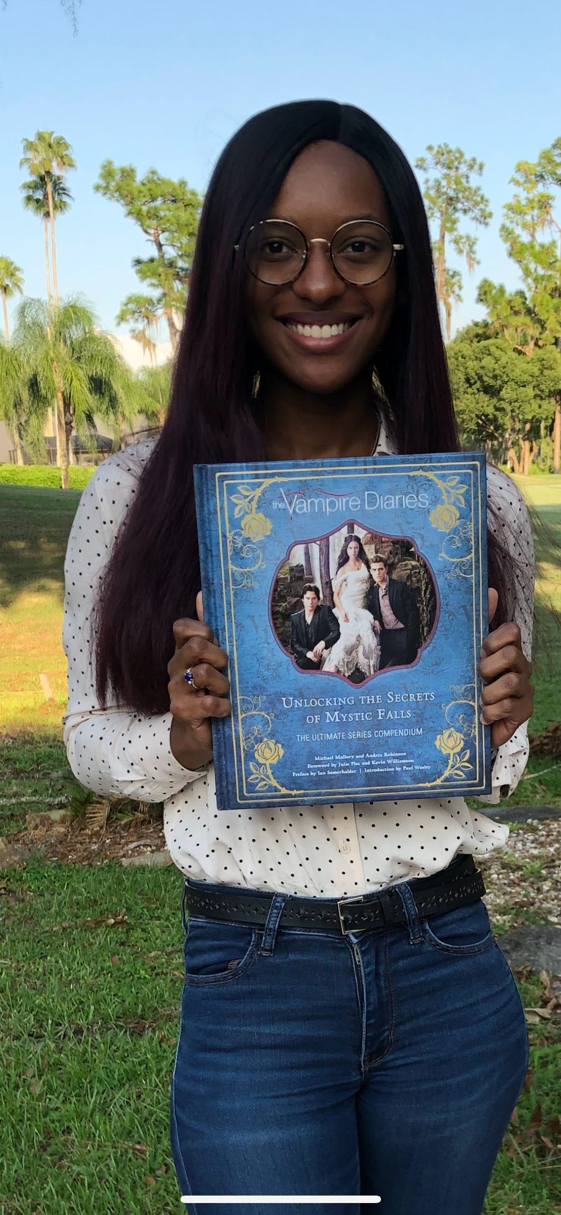 A photo of Kat Lewis holding the book, The Vampire Diaries: Unlocking the Secrets of Mystic Falls.
