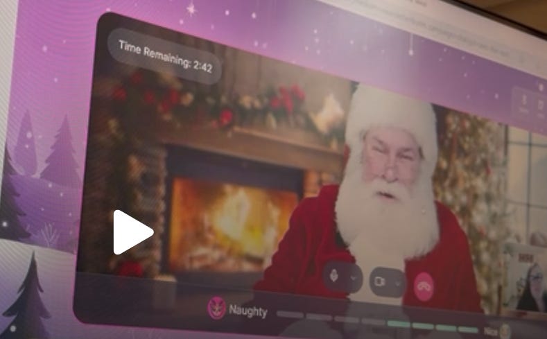 Computer Screen showing video call with Santa who is sat in front of a roaring fire.  In the bottom right corner is Yolanda Barker who is interviewing Father Christmas.