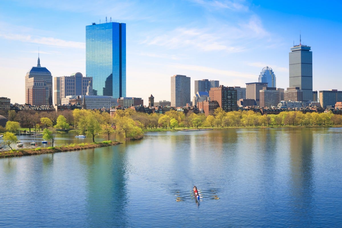 A photo of Boston's Charles River with the skyline and a rowboat A photo of Boston's Charles River with the skyline and a rowboat