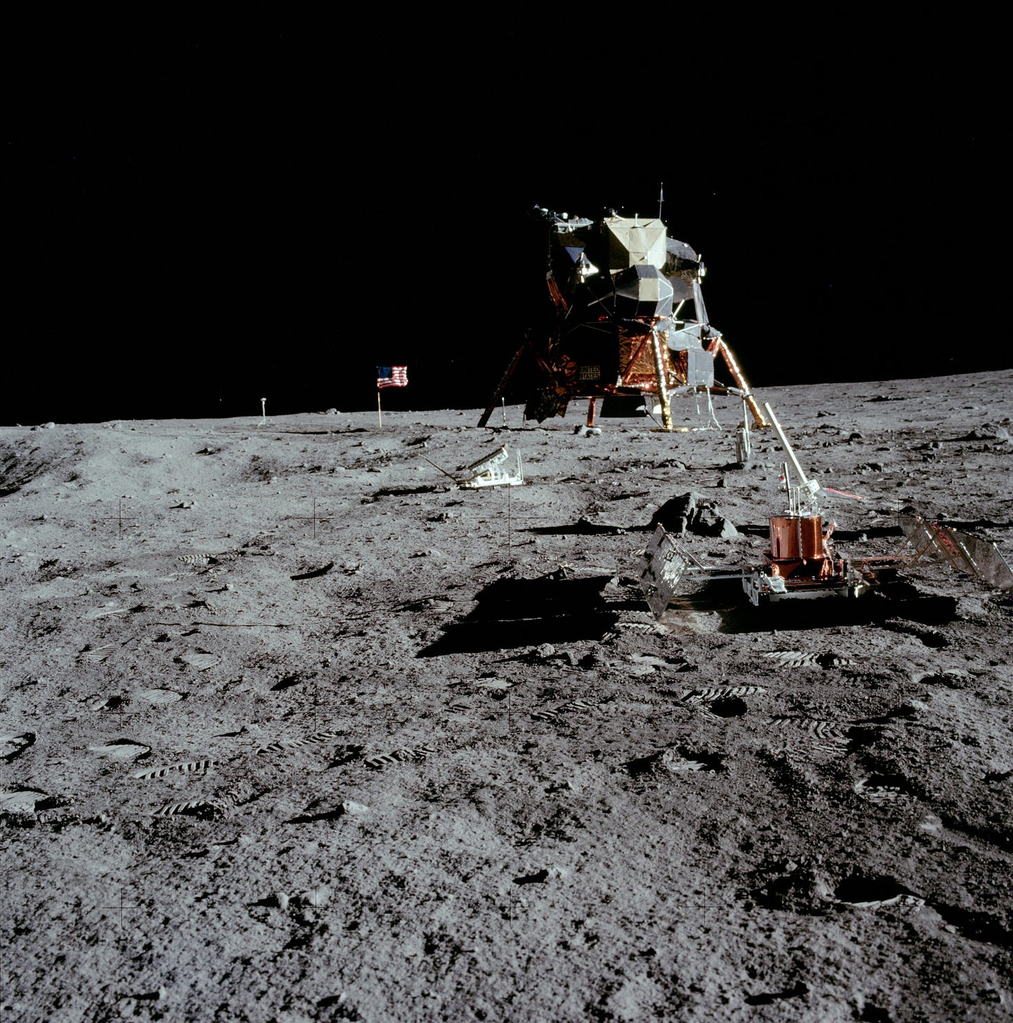 Photo of the Apollo 11 landing site with lander, sensing equipment, and the American flag