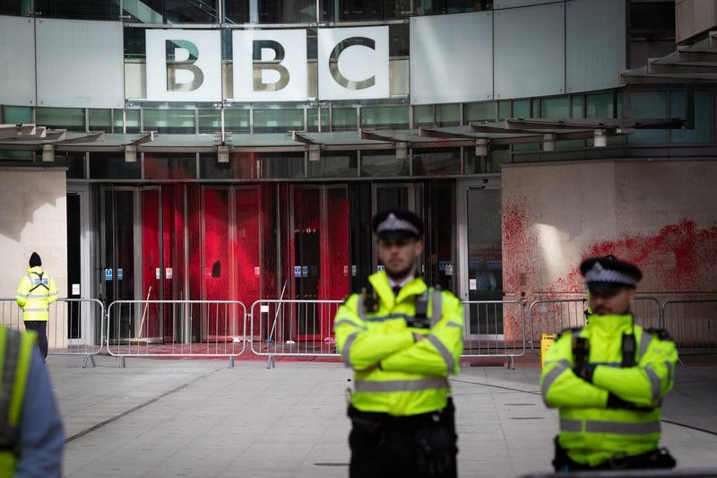 A british policeman stands guard outside the paint splattered offices of the BBC A british policeman stands guard outside the paint splattered offices of the BBC