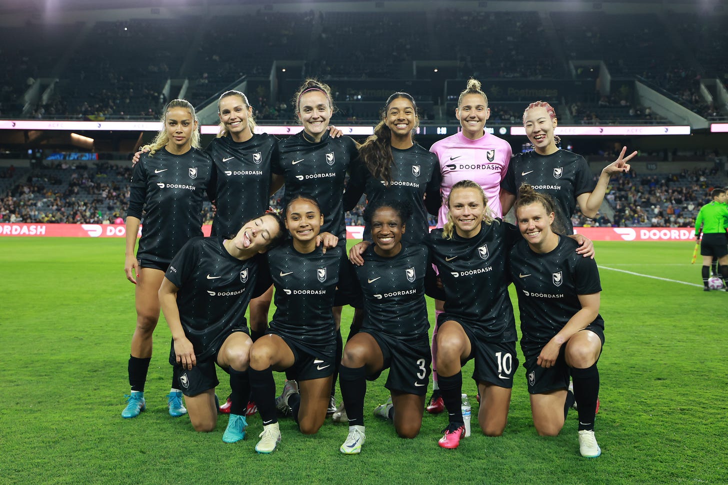 Angel City FC player Madison Hammond smiles in a lineup photo alongside her teammates ahead of 2023 preseason friendly.