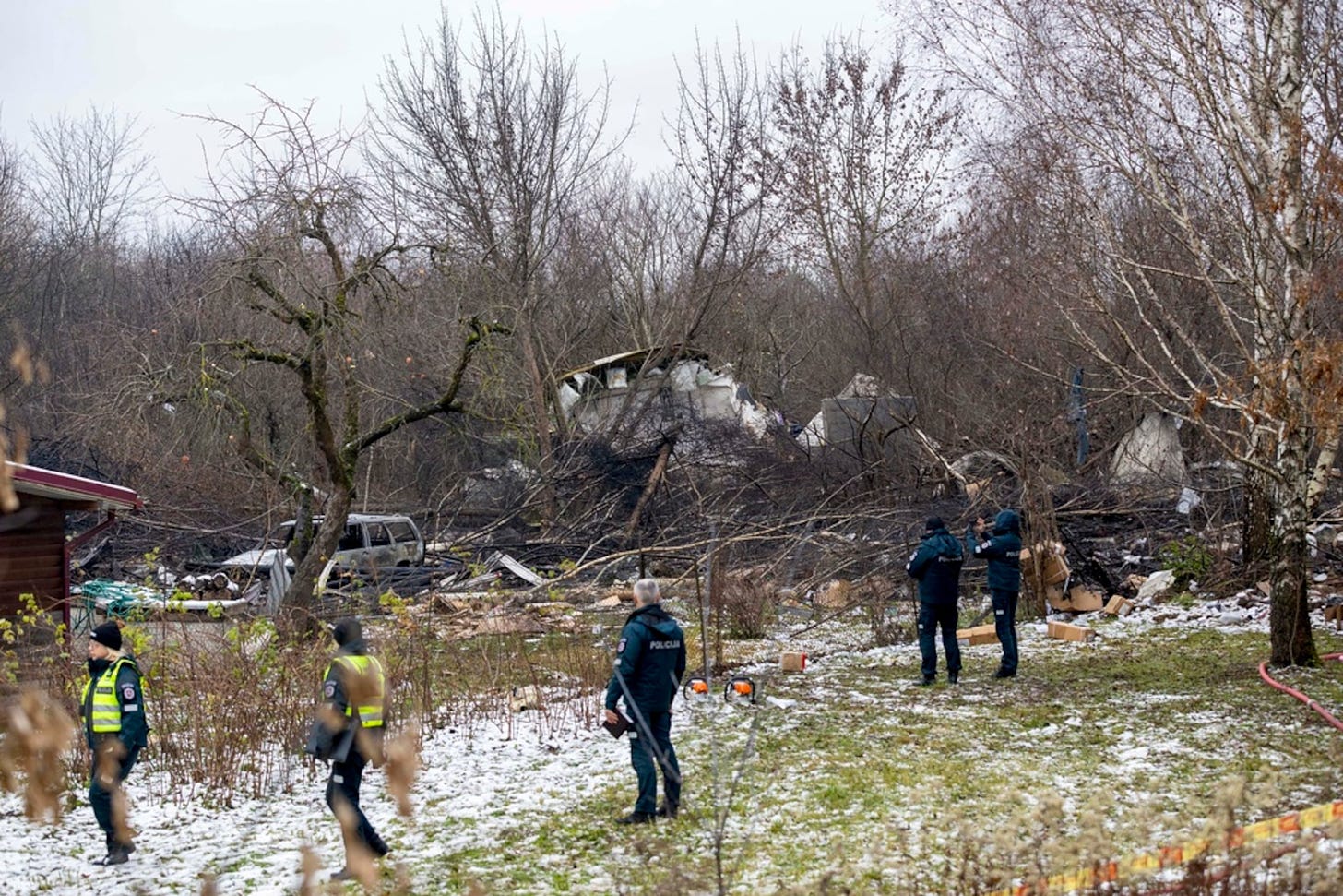 Empleados del Ministerio de Emergencias de Lituania y policías cerca del lugar donde el avión se estrelló en Vilna, Lituania, este lunes.