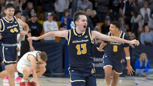 UC San Diego guard Tyler McGhie (13) celebrates after defeating Utah State in an NCAA college basketball game Tuesday, Dec. 17, 2024, in Logan, Utah. (Eli Lucero/The Herald Journal via AP)