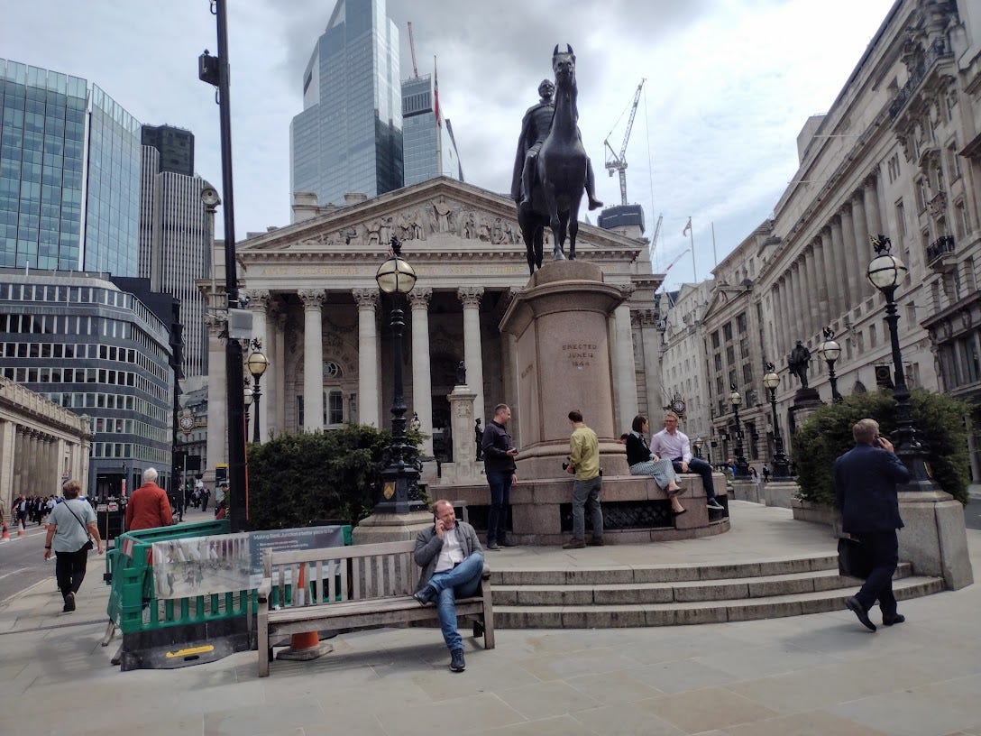Large classical building with statue of man on horse in front