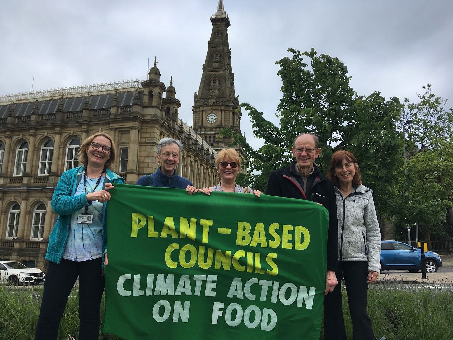 5 people stand with a banner saying plant based councils climate action on food