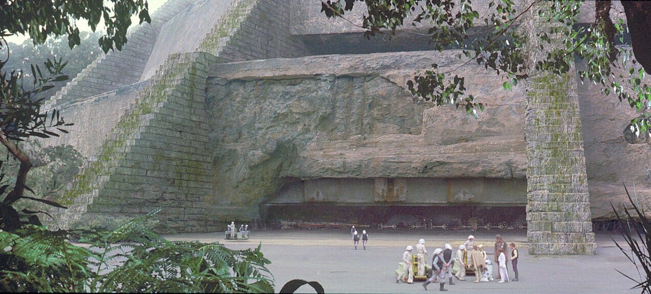 Yavin 4 | StarWars.com - a group of Rebels standing outside the massive stone temple-turned-base
