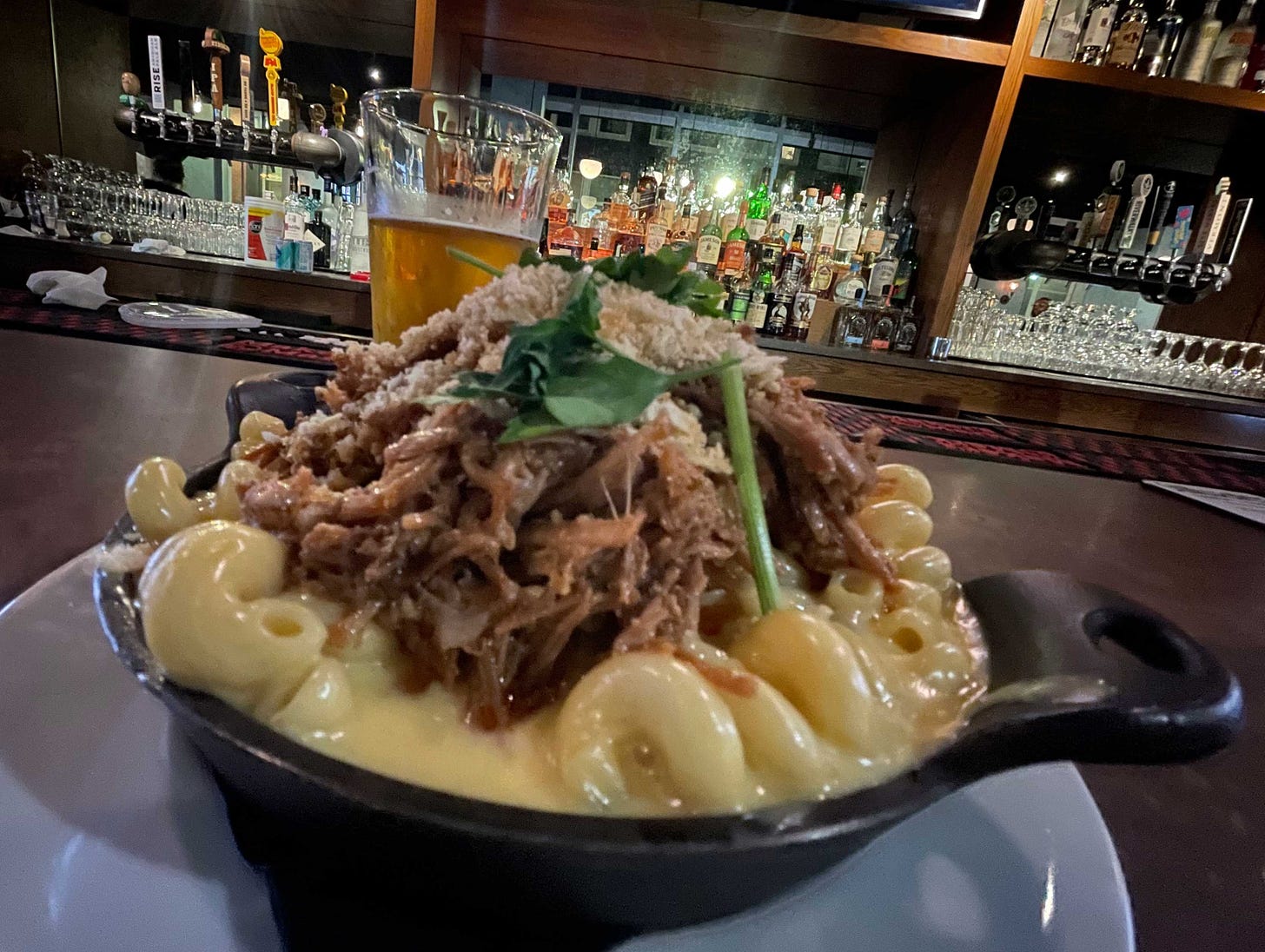 Skillet containing macaroni and cheese with pulled pork.