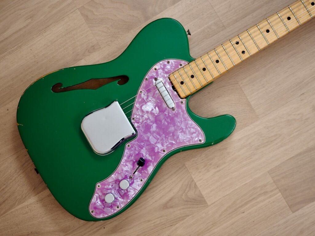 1971 Fender Telecaster Thinline in Kelly Green gloss finish and purple pearloid pickguard laid on the wooden floor.