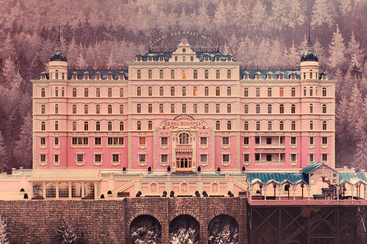 A symmetrical pastel-colored building with quirky details, reminiscent of a Wes Anderson film set