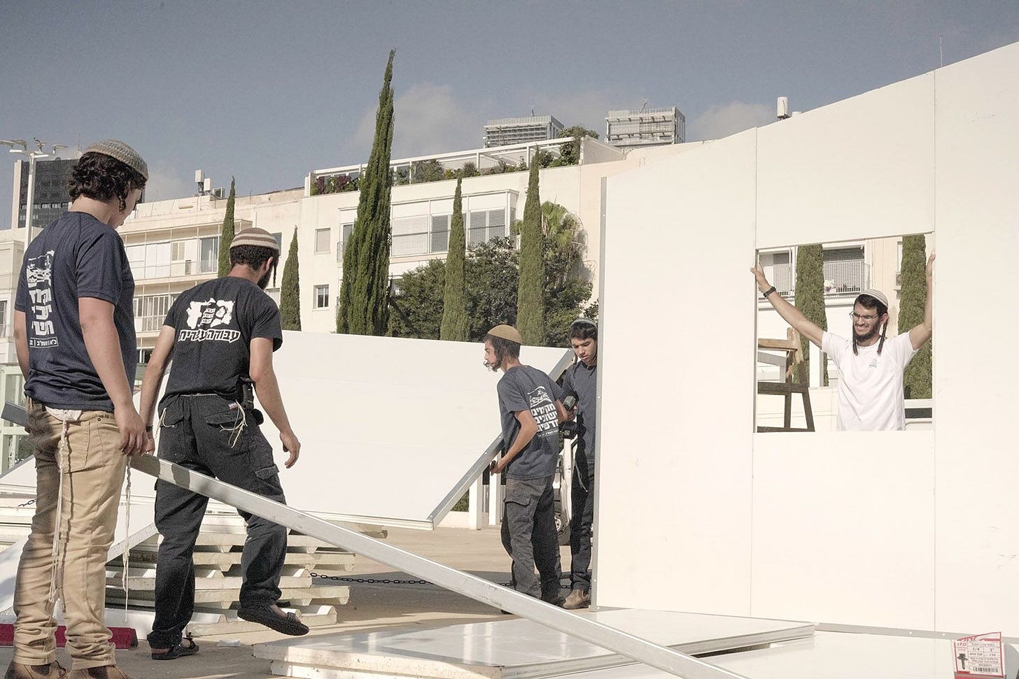 Settler activists constructing a pre-fabricated home for a rally in Habima Square, Tel Aviv, on July 16, 2022. (Photo by Natan Odenheimer)