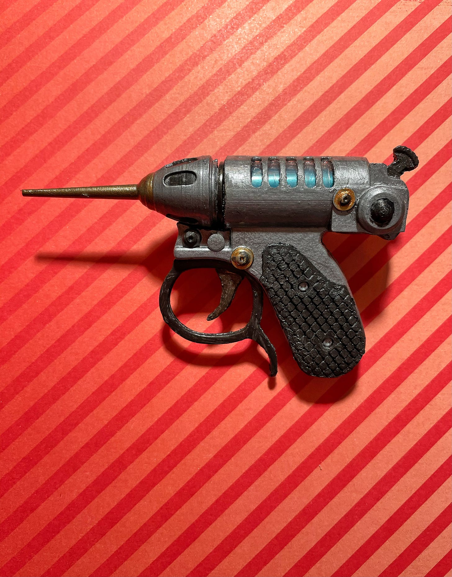 3D printed gun on striped background.