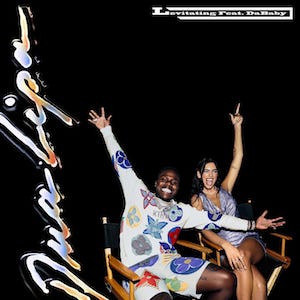 Dua Lipa and DaBaby sitting in movie chairs, posing with their hands in the air over a black background. DaBaby wears a white outfit with mult-coloured designs, while Lipa wears a blue dress. Lipa's name appears vertically in silver on the left, while the title "Levitating feat DaBaby" appears in the top right in white.