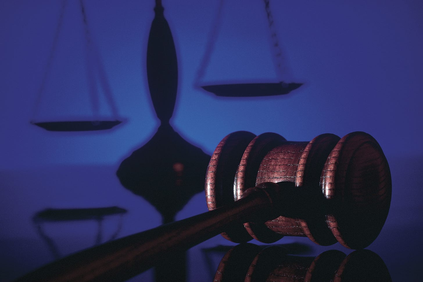 A gavel with the scales of justice in the background.