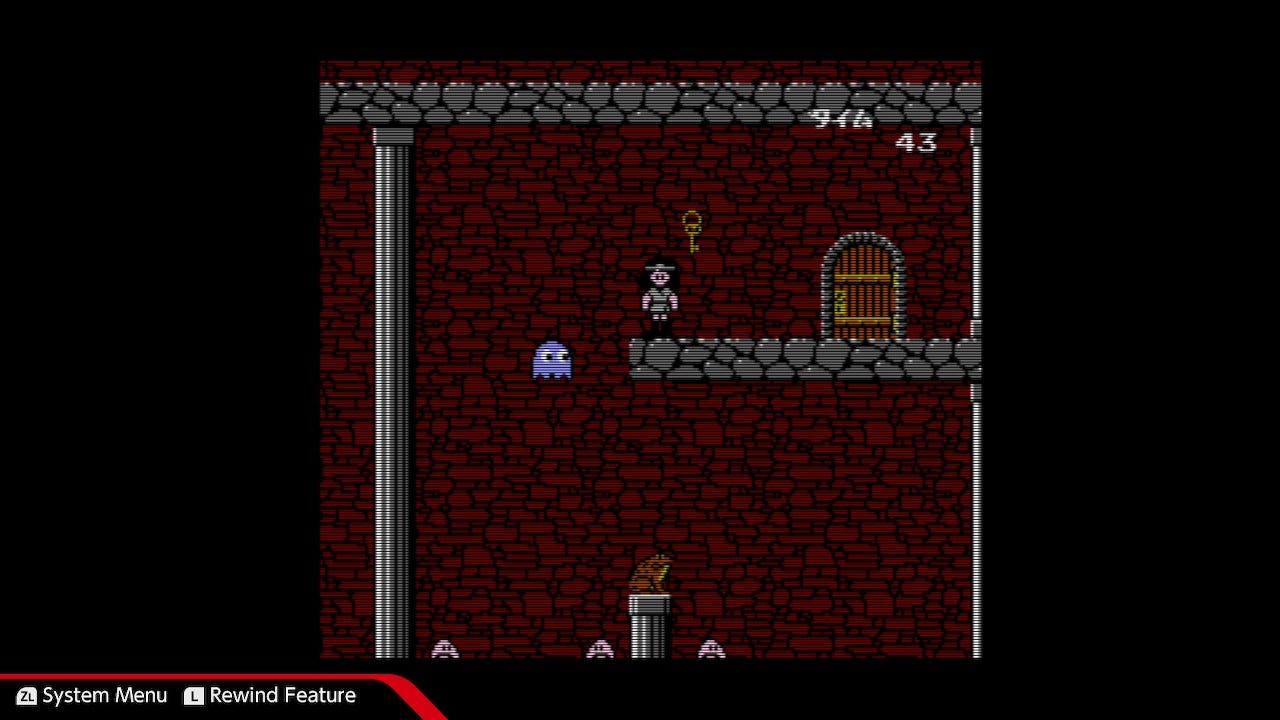 A screenshot from The Quest of Ki, captured on the Nintendo Switch, that shows the blue Pac-Man ghost, Inky, floating near Ki, who has collected the key that opens the exit door.