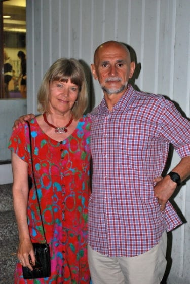 a woman in a red dress with a man in a checkered shirt