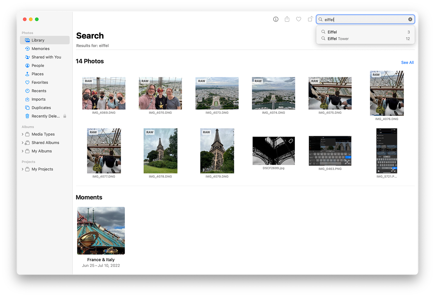 Screenshot of Apple Photos showing search results for the term "Eiffel." 14 photo thumbnails and one Moment are displayed.