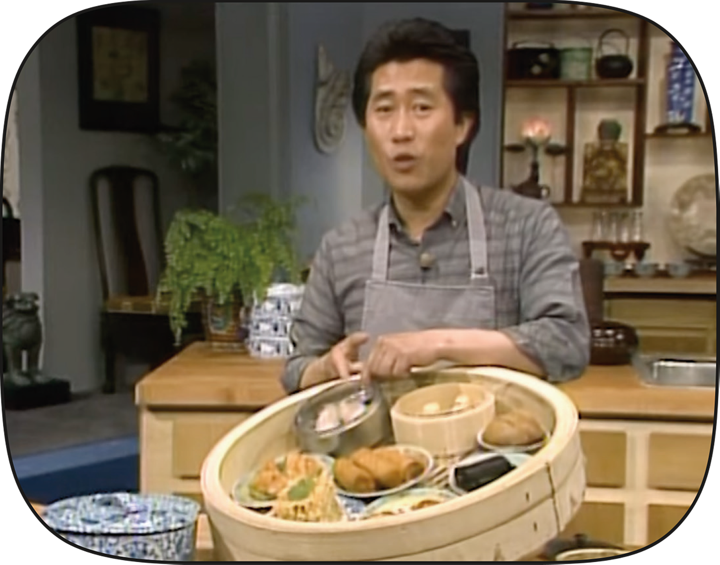Martin Yan in his studio kitchen pointing out different kinds of dim sum.