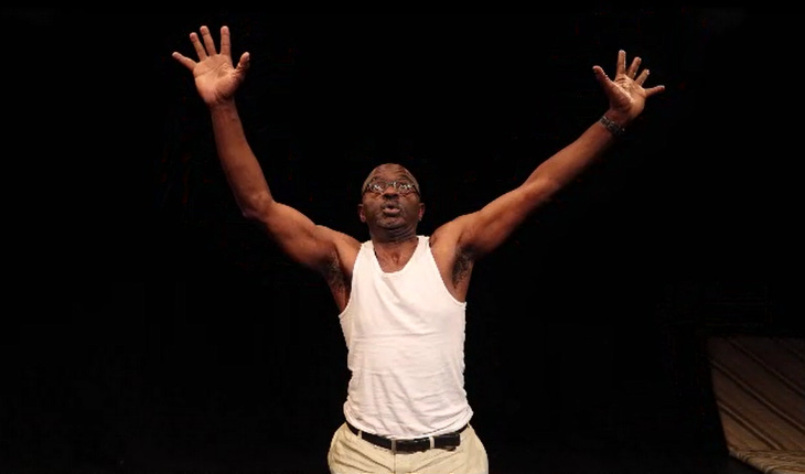 Tayo Aluki on stage in a white vest