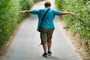 single woman walking down a road by herself