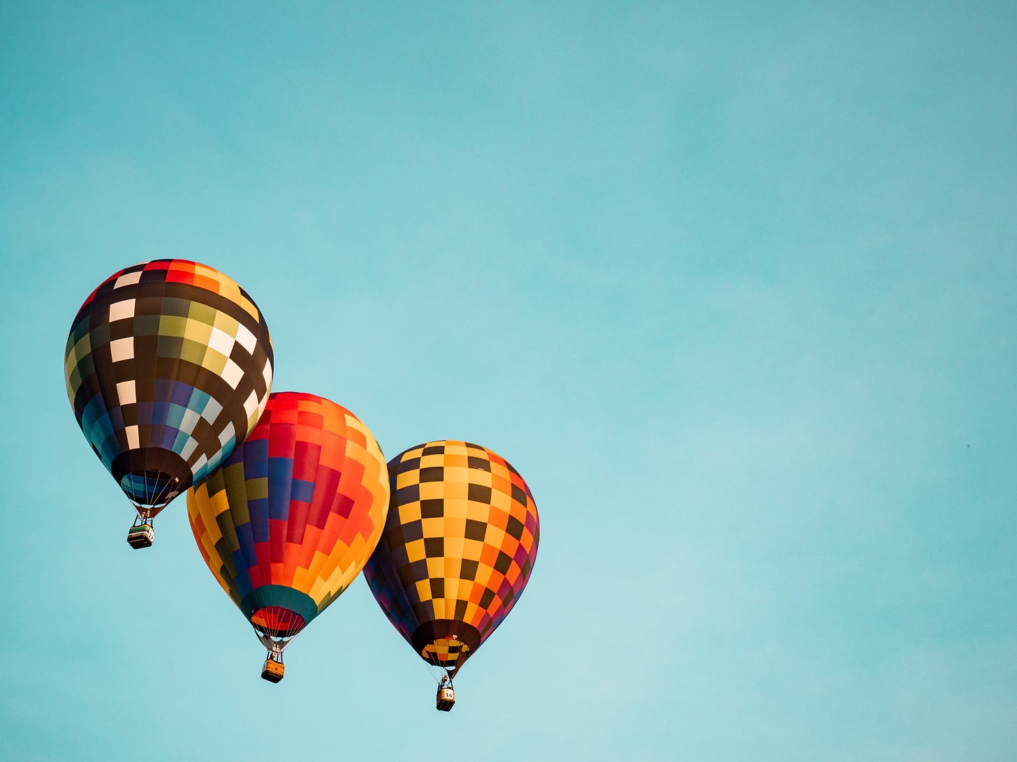 three colourful hot air balloons in sky