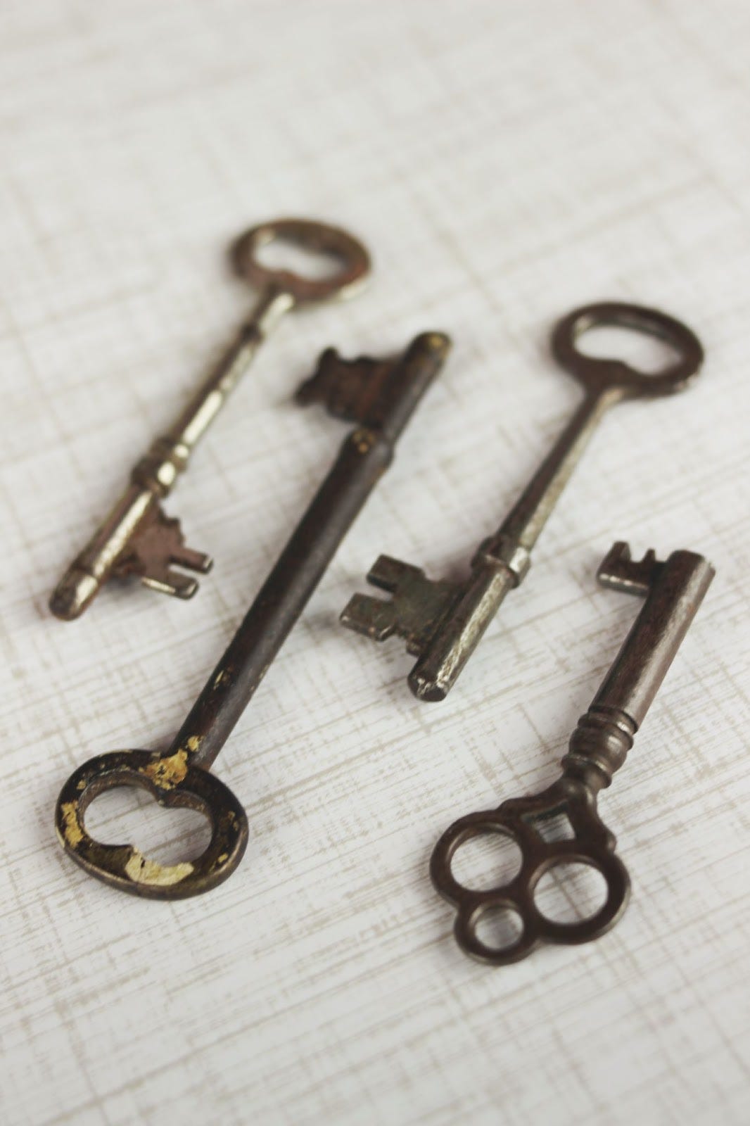 four antique keys lying on a crosshatched background. four antique keys lying on a crosshatched background.