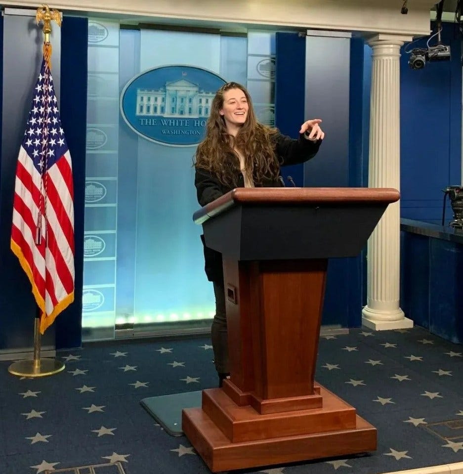 Woman giving a presentation at a podium in the White House briefing room.