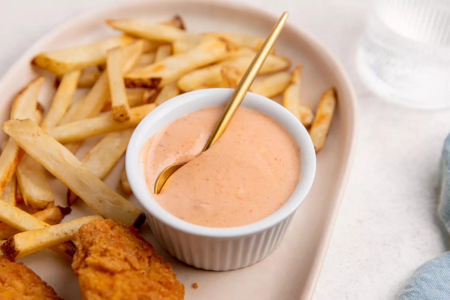 Southern Living Comeback Sauce in a ramekin on a plate with fries and chicken fingers