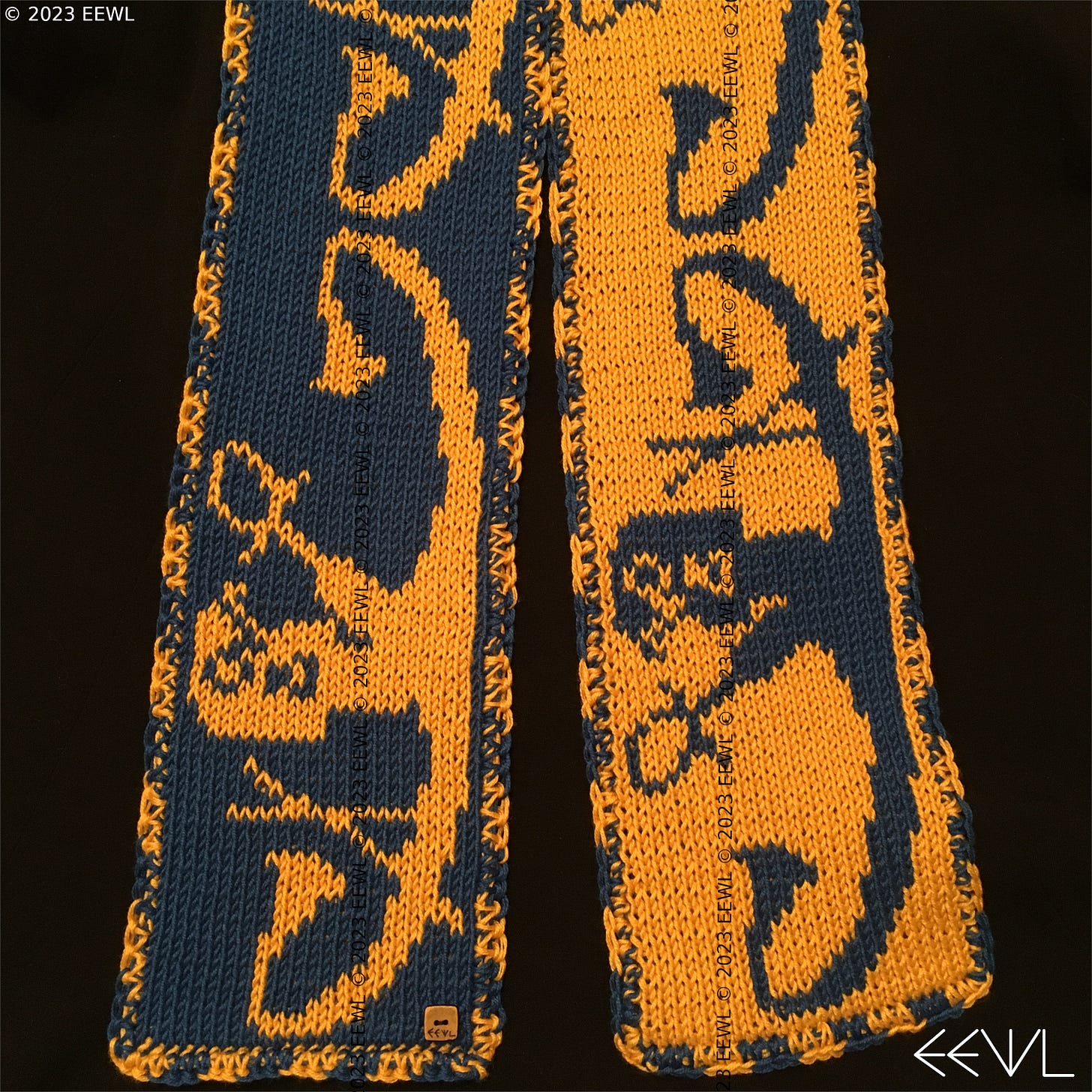 Images of both sides of a blue and yellow hand-knitted scarf. The pattern on the scarf features the Ancient Egyptian sun god Ra traveling across the sky in his solar barque, or boat.