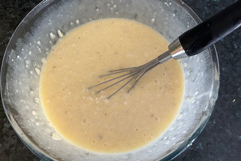 Whisking eggs, stock and rice.