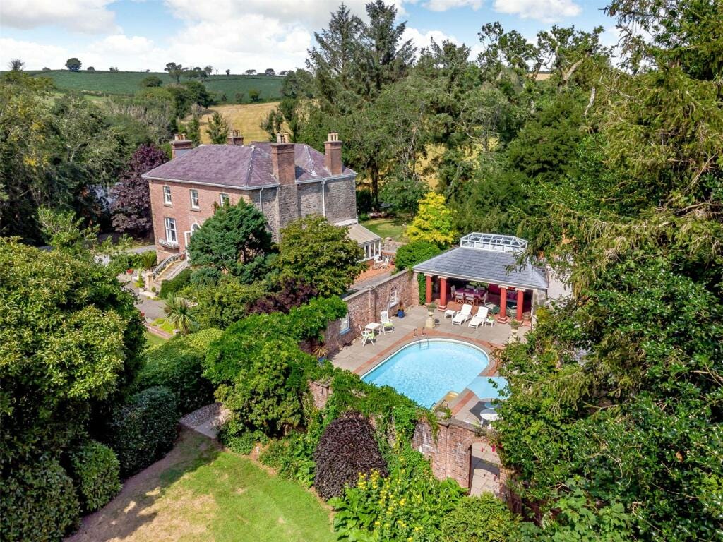 A large three storey detached house with separate pool house and swimming pool. There's lovely walled gardens and huge mature trees all around. 