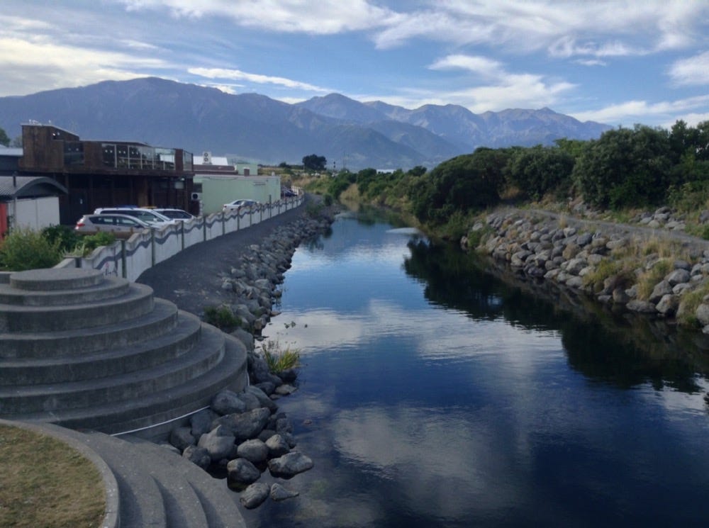 A river wends through town, mountains behind