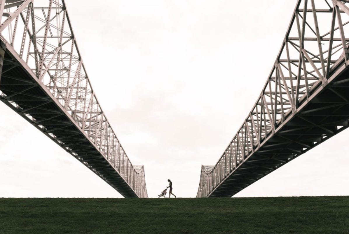 2 bridges extending into distance as someone walks between them