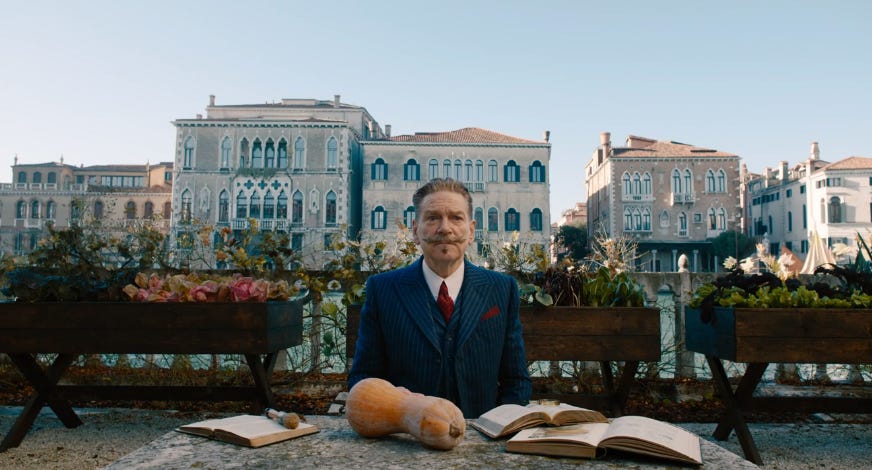 Screencap from A Haunting in Venice, Poirot looking alone and estranged against a backdrop of elegance.