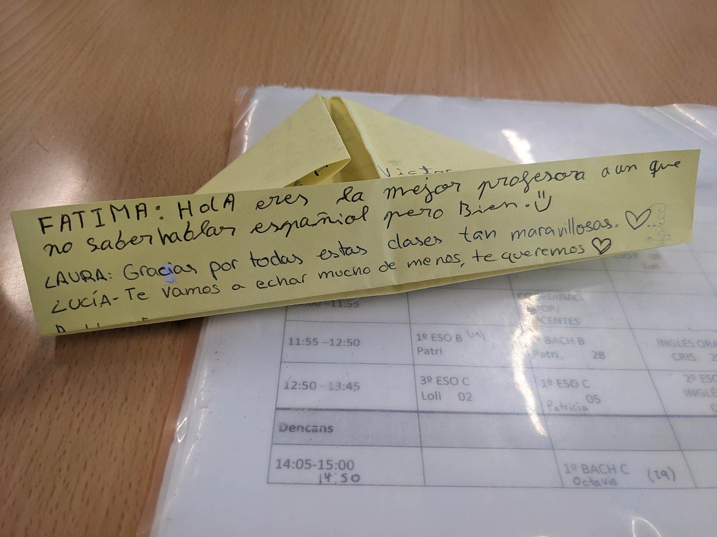 A folded piece of paper with three messages written on it in Spanish.