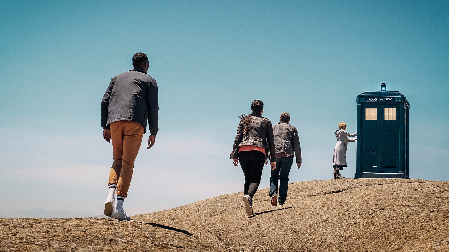 This image shows Team TARDIS walking toward the TARDIS, which sits atop a rocky ridge. The Thirteenth Doctor (played by Jodie Whittaker) touches the TARDIS's door, while, in order, Graham O'Brien (played by Bradley Walsh), Yasmin "Yaz" Khan (played by Mandip Gill), and Ryan Sinclair (Tosin Cole) walk toward her. This image shows Team TARDIS walking toward the TARDIS, which sits atop a rocky ridge. The Thirteenth Doctor (played by Jodie Whittaker) touches the TARDIS's door, while, in order, Graham O'Brien (played by Bradley Walsh), Yasmin "Yaz" Khan (played by Mandip Gill), and Ryan Sinclair (Tosin Cole) walk toward her.