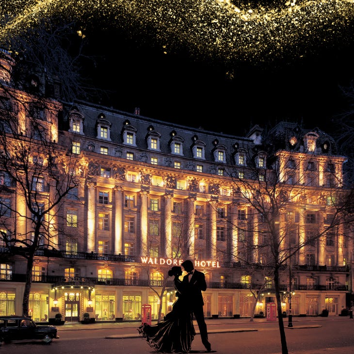 A couple dancing outside a grand, colonnaded hotel