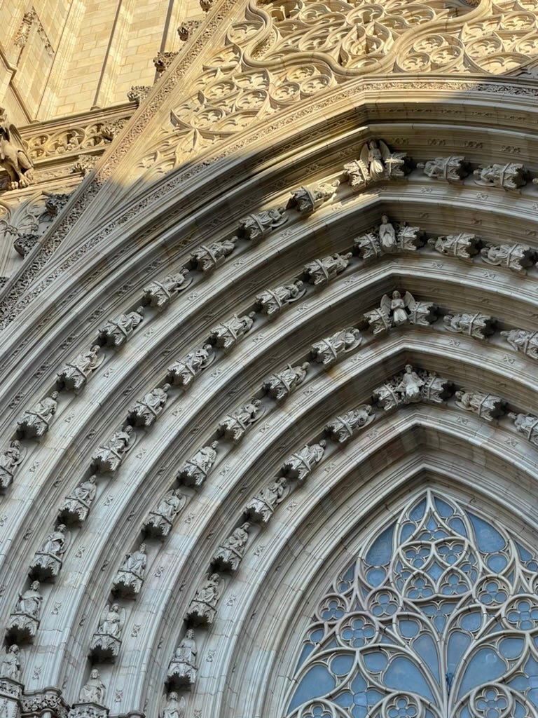 A picture of an archway of the Barcelona cathedral featuring angels getting progressively more horizontal.