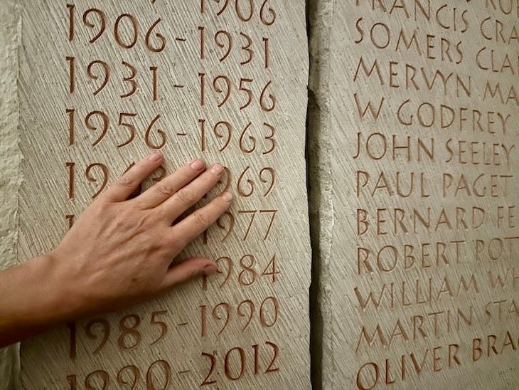 A hand brushes over some dates on a carved stone in St Paul's crypt. Probably shouldn't be touching the memorials. But it is the hand of someone with 30 years experience carving stone, so we'll let her off