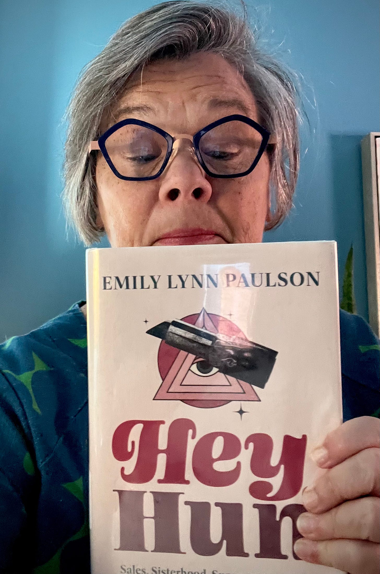 white woman looking down at the book "Hey Hun" by Emily Lynn Paulson