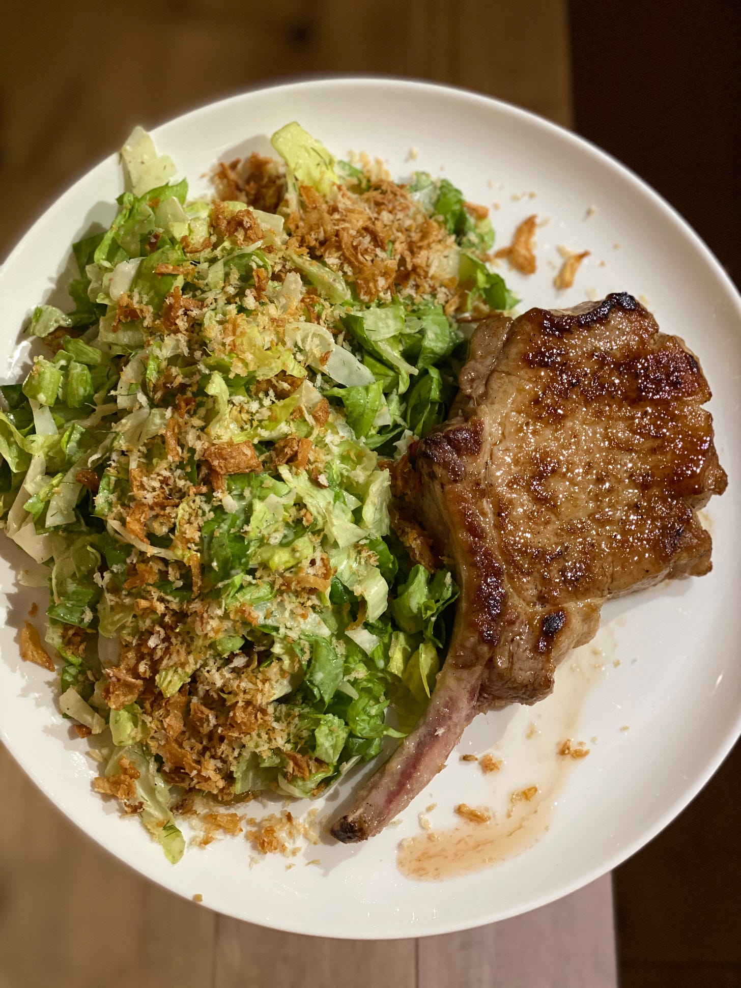 juicy browned pork chop with salad topped with panko