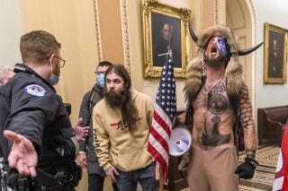 FILE - Supporters of President Donald Trump, including Jacob Chansley, right with fur hat, are confronted by U.S. Capitol Police officers outside the Senate Chamber inside the U.S. Capitol, Jan. 6, 2021, in Washington. Chansley, the spear-carrying rioter whose horned fur hat, bare chest and face paint made him one of the more recognizable figures in the Jan. 6, 2021, assault on the Capitol, apparently aspires to be a member of Congress. Online paperwork shows that Chansley filed a candidate statement of interest, Thursday, Nov. 9, 2023, indicating he wants to run as a Libertarian in the 2024 election for Arizona’s 8th Congressional District seat. (AP Photo/Manuel Balce Ceneta, File)