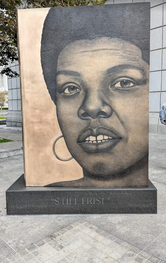 An image of a monument honoring Maya Angelou stands outside of the Main Branch of the San Francisco Library.