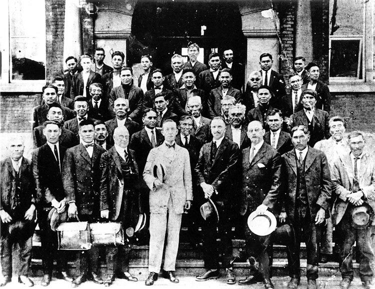 The image is a group photograph to commemorate the amalgamation. The photo was taken outside Dept. of Indian Affairs building, Vancouver. Most identified.
