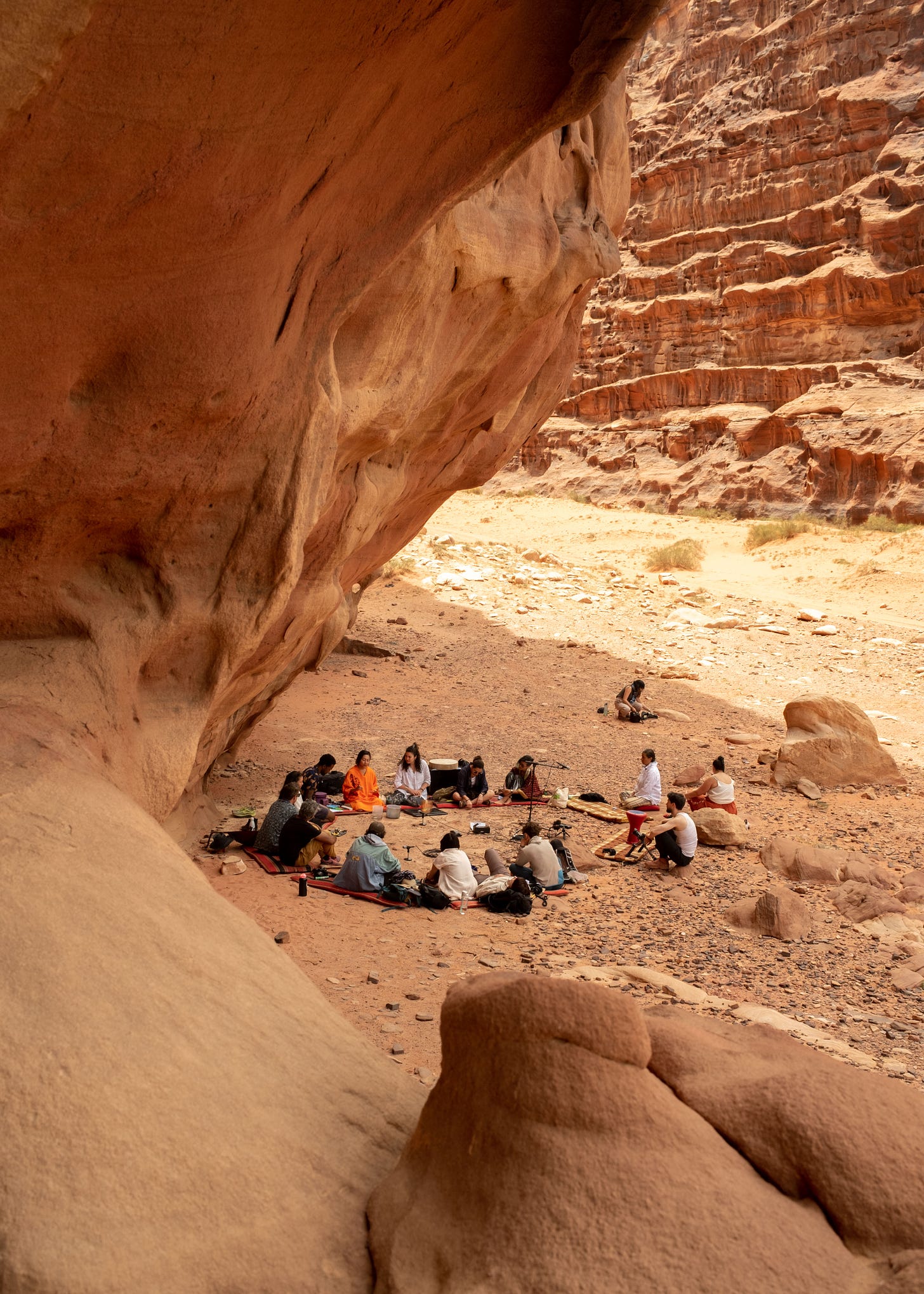 People sitting in a circle in a canyon in Wadi Rum